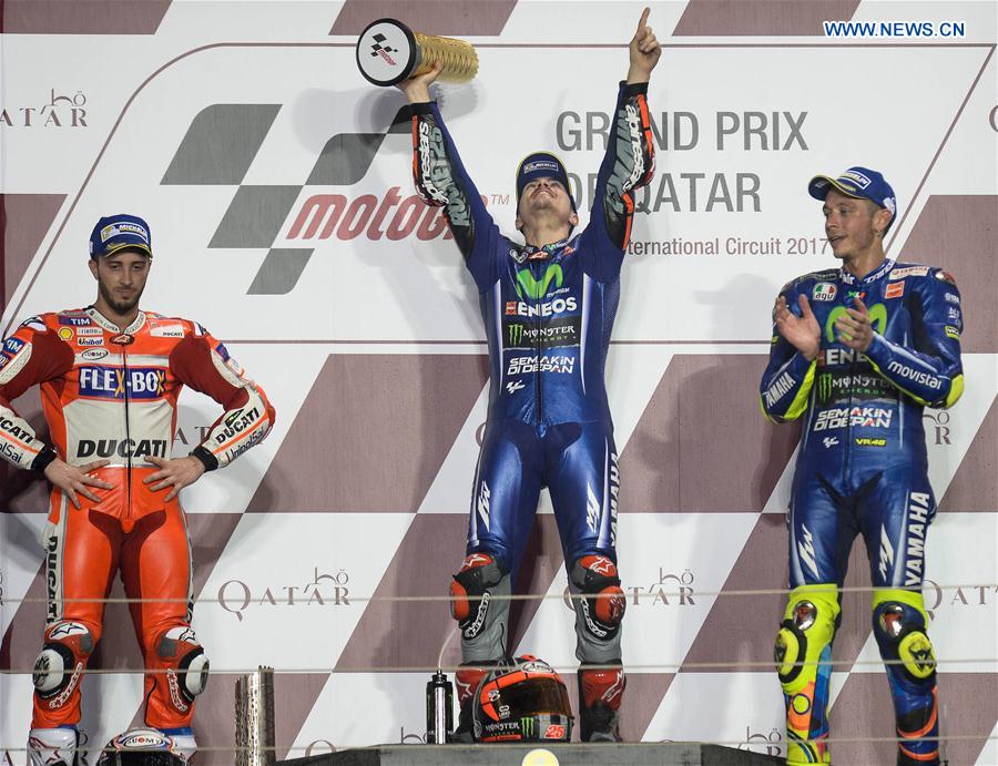 Movistar Yamaha MotoGP's Spanish rider Maverick Vinales(C) celebrates during the awarding ceremony for the 2017 FIM MotoGP Grand Prix of Qatar at the Losail International Circuit in Doha, capital of Qatar, on March 26, 2017. 