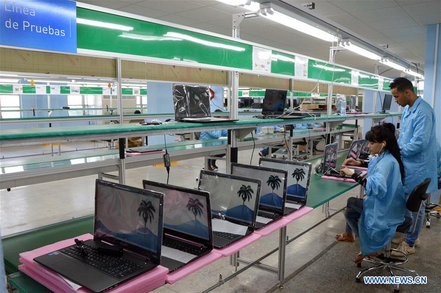 Image taken on March 20, 2017 shows staff members working at a national laptop and tablet factory, in Havana, Cuba. 