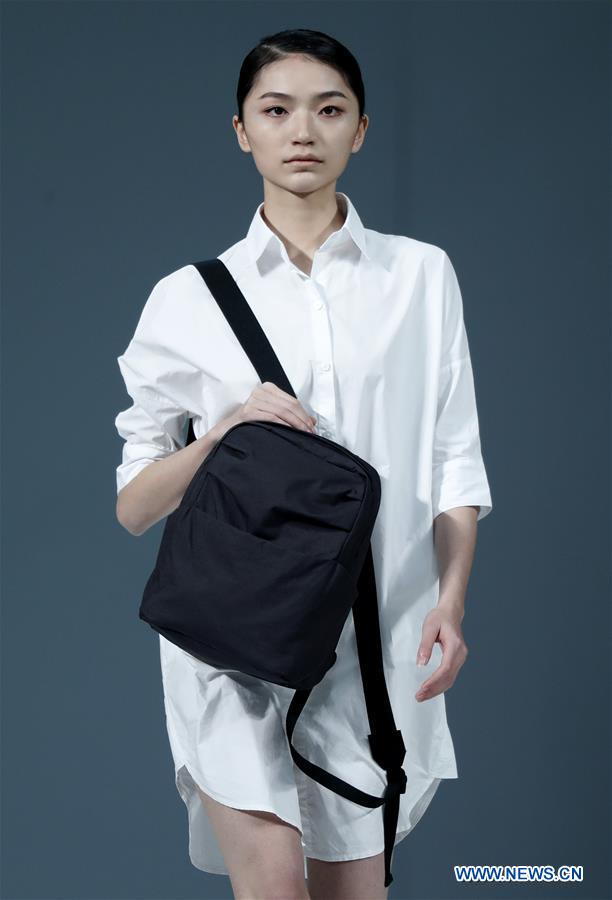 A model presents a hand bag designed by Liu Shengyi during China Fashion Week in Beijing, capital of China, March 30, 2017. 