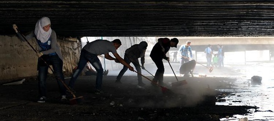 Young Syrians clean aqueduct connecting Barada River in Damascus