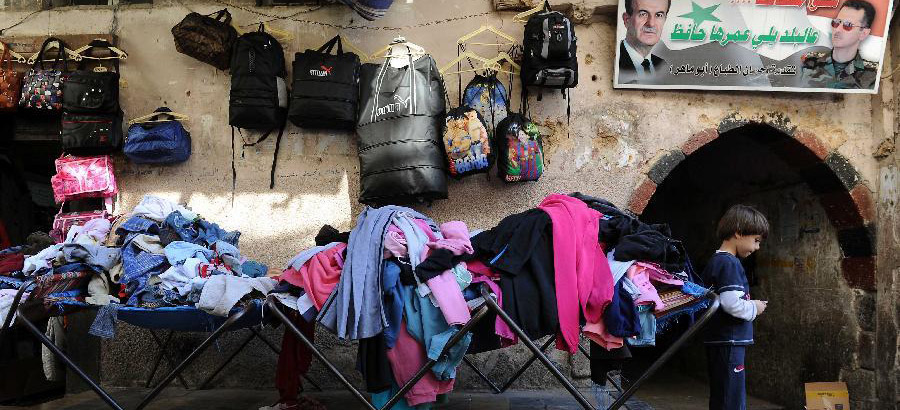 Syrian men deal in second-hand clothes market in Damascus