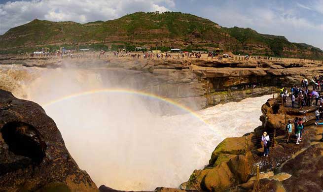 Tourists view Hukou Waterfall of Yellow River in NW China