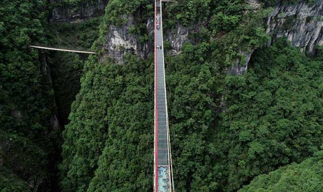 People walk on glass-bottom bridge in Jianshi County, C China
