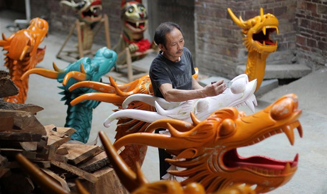 Chinese folk artist makes dragon head for bow of dragon boat