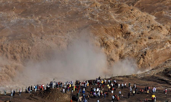 People watch scenery at Hukou Waterfall scenic spot in China's Shanxi