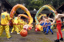 Volunteers perform dragon and lion dance for villagers in SW China's Sichuan