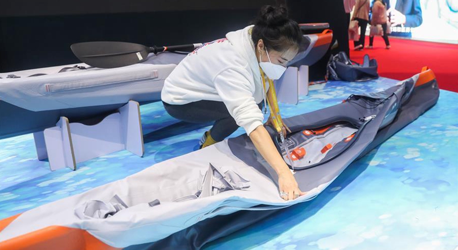 Staff member demonstrates how to use foldable kayak at 3rd CIIE