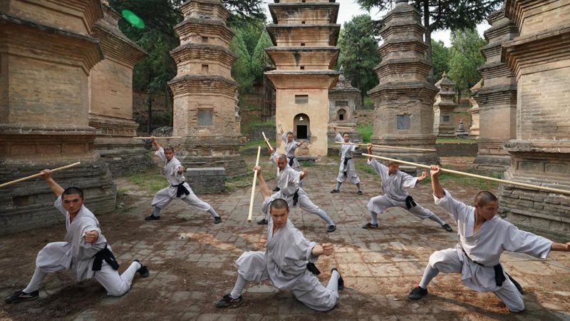 Shaolin monks practice martial arts at Pagoda Forest of Shaolin Temple in Henan