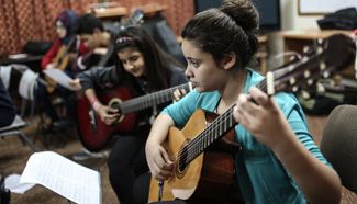Gaza youth learn to play music instruments at school