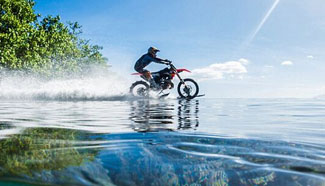 Stunt rider 'surfs' wave on a motorbike
