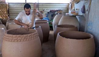 Iraqi worker makes pottery jars in Kadhimiya