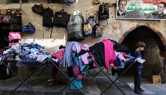 Syrian men deal in second-hand clothes market in Damascus