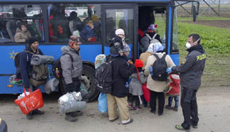 Migrants wait to be transfered to refugee centre inland Slovenia