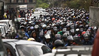 People queue up with their motorcycles for fuel in Kathmandu