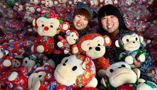 Workers display monkey dolls for customers in E China
