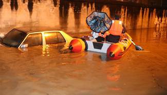 In pics: Rescuers take rubber dinghy on flooded road, S China