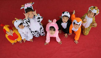 Kindergarten children pose for a graduation photo, central China