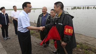 Premier Li Keqiang emphasizes protecting people's lives, ensuring safety of key embankments 
and facilities