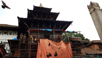 People work at reconstruction site of damaged temple in Nepal