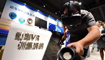 Visitors try on VR equipments at experience center in SE China