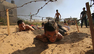 Palestinian children take part in military exercise at summer camp
