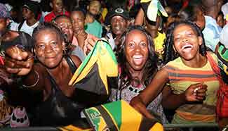 People celebrate Jamaican athletes winning gold of men's 4x100m relay