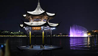 Tourists view night scene of West Lake in Hangzhou
