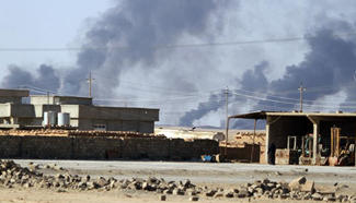 Heavy smoke rises from oil wells in Qayyarah Town, Iraq