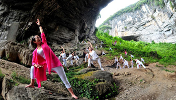 Yoga fans practice at central China's Moon Rock sinkhole
