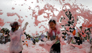 Children play with bubbles at scenic spot in SW China