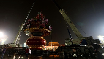 Workers set up large flower terrace in rain on Tian'anmen Square in Beijing