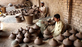 Workers make pottery at workshop in Pakistan's Peshawar