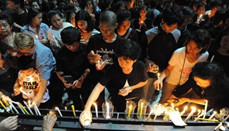Mourners light candles to pray for late Thai King in central Thailand