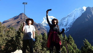 Tourists take selfie on trekking route of Himalayas in Nepal