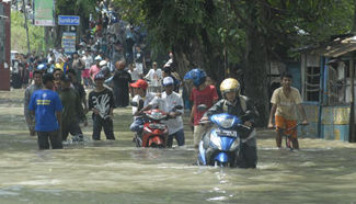 People wade through flood water in Sukoharjo, Indonesia