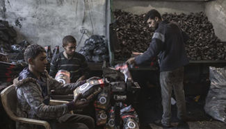 Palestinian workers repack charcoal imported from Egypt in Gaza City