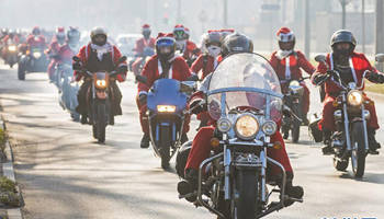 "Santa Clauses" ride motorcycles to take part in parade
