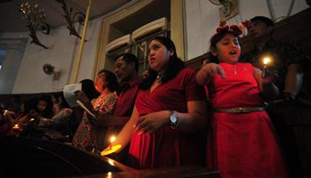Indonesian Christians hold candles on Christmas Eve at church