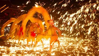 People perform fire dragon dance for New Year, SW China