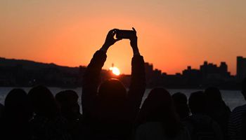 People view sunset at Tamsui River in SE China's Taiwan