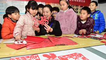 Teacher introduces skills of window paper-cutting to children in E China