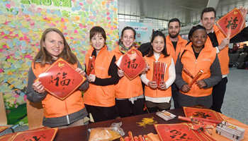 Foreign volunteers offer help to passengers during chunyun in Hangzhou