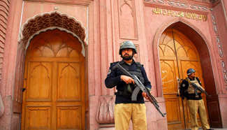 Pakistani policemen stand guard outside mosque in Peshawar