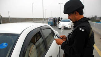 Pakistani policemen check people in Peshawar