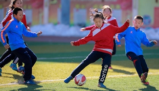 Primary school students participate in soccer training in N China