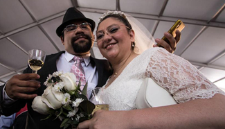 Couple poses after getting married during collective wedding ceremony in Mexico City