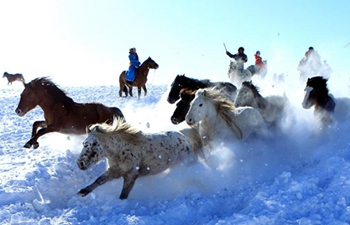 Herdsmen tame horses on snow-covered pasture in N China