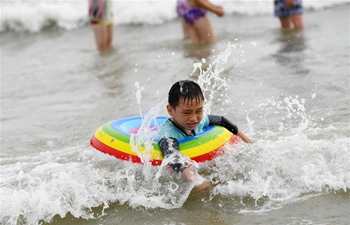 People play with water on beach in Beihai, S China's Guangxi