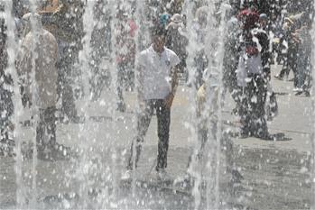 People play with water to cool down in Tunis