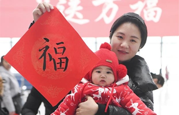 Calligraphy enthusiasts write Chinese character "Fu" at railway station